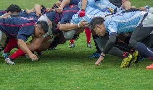 Ein Rugby-Team beim Scrum auf dem Feld